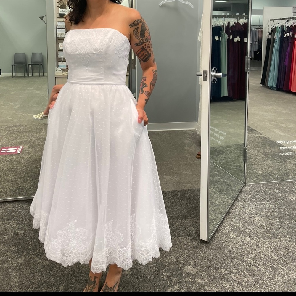 Classy tea length lace wedding dress with structured bodice and full skirt.